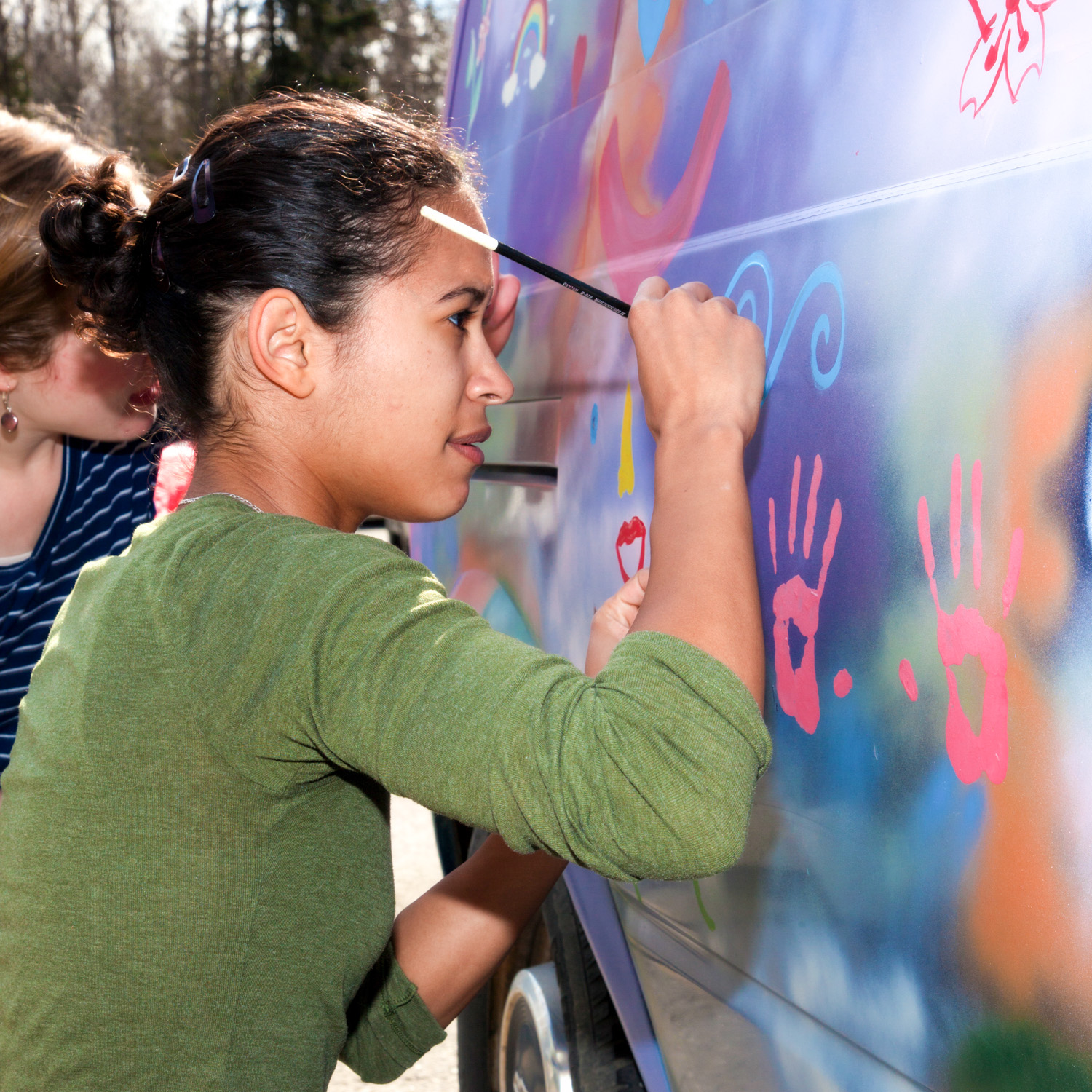 Students painting a van.