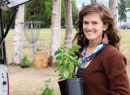 Megan Talley of Spring Creek Farm carries potted basil to the market stand