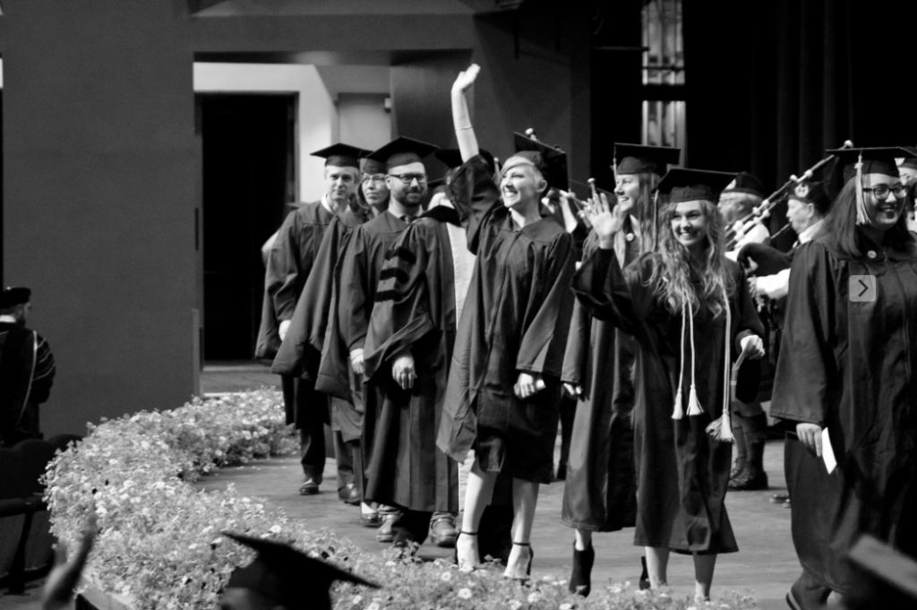 Happy graduates waving to the audience during Spring 2017 APU Graduation Ceremony