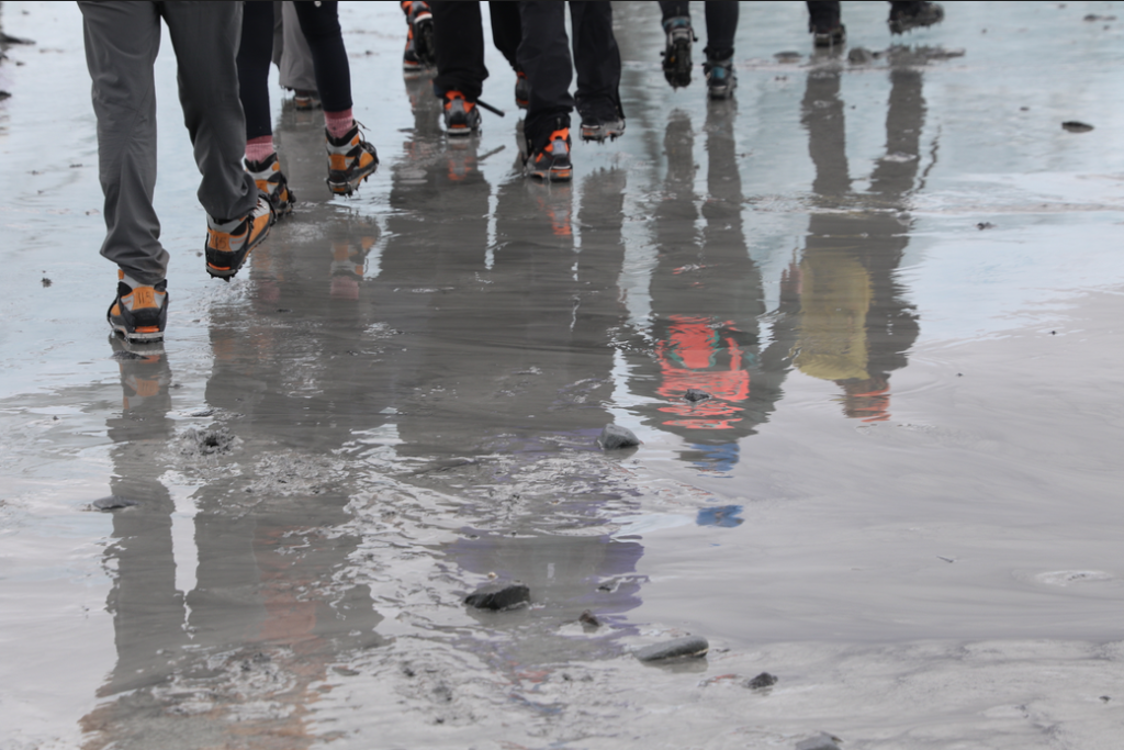 View of students' feet with cleats on the ice.
