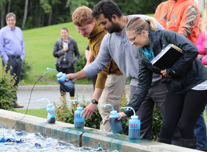 Group of three squirt the blue dye into the APU Atwood Building fountain.