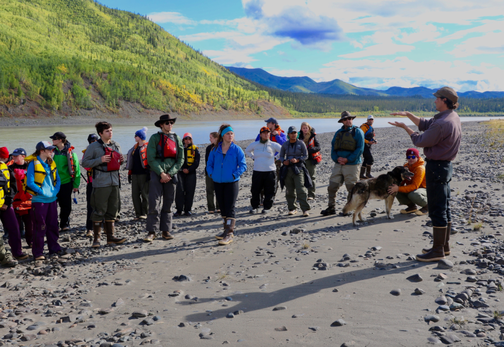 Faculty member lecturing students along the Yukon River.