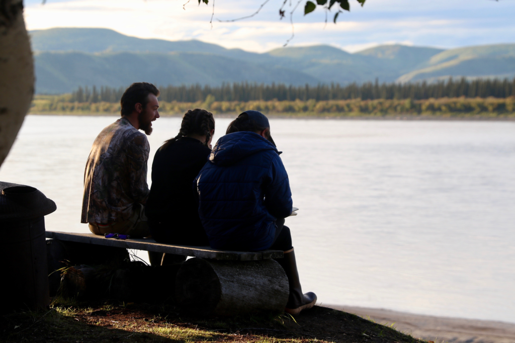 Students sitting on a bench along the Yukon River.