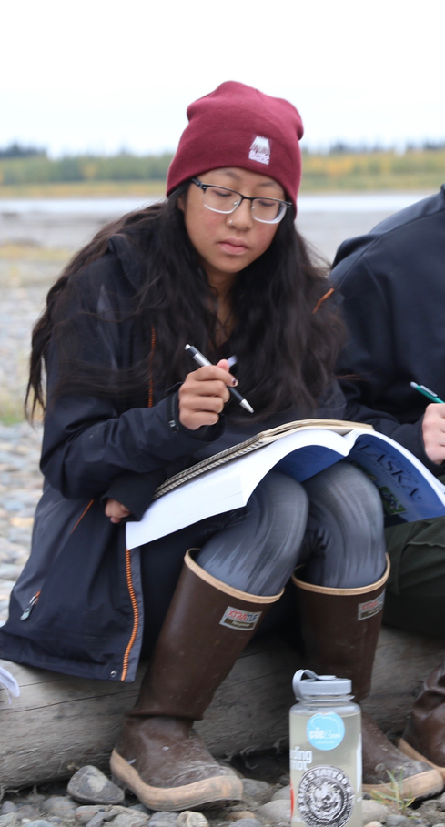Student studying along the Yukon River.