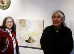Elder poses next to art