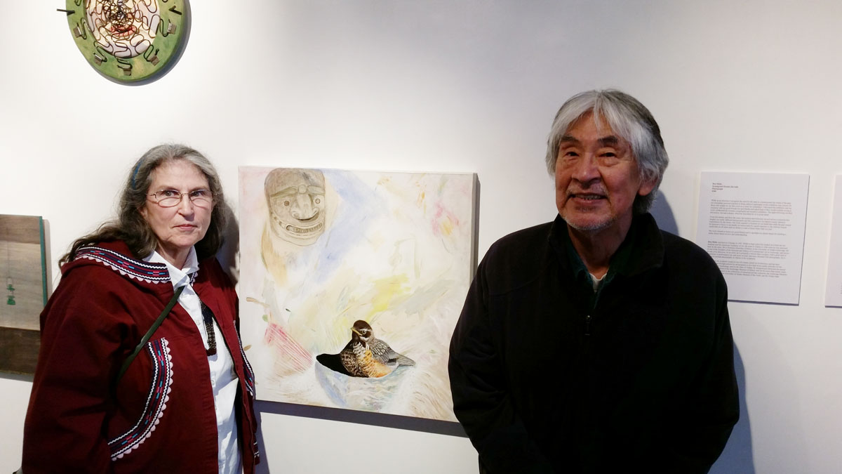 Elder poses next to art