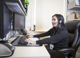 Person in office at computer with headset on