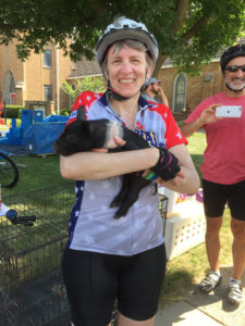 Sheila King cradled a baby pig while resting from a bicycle trip.