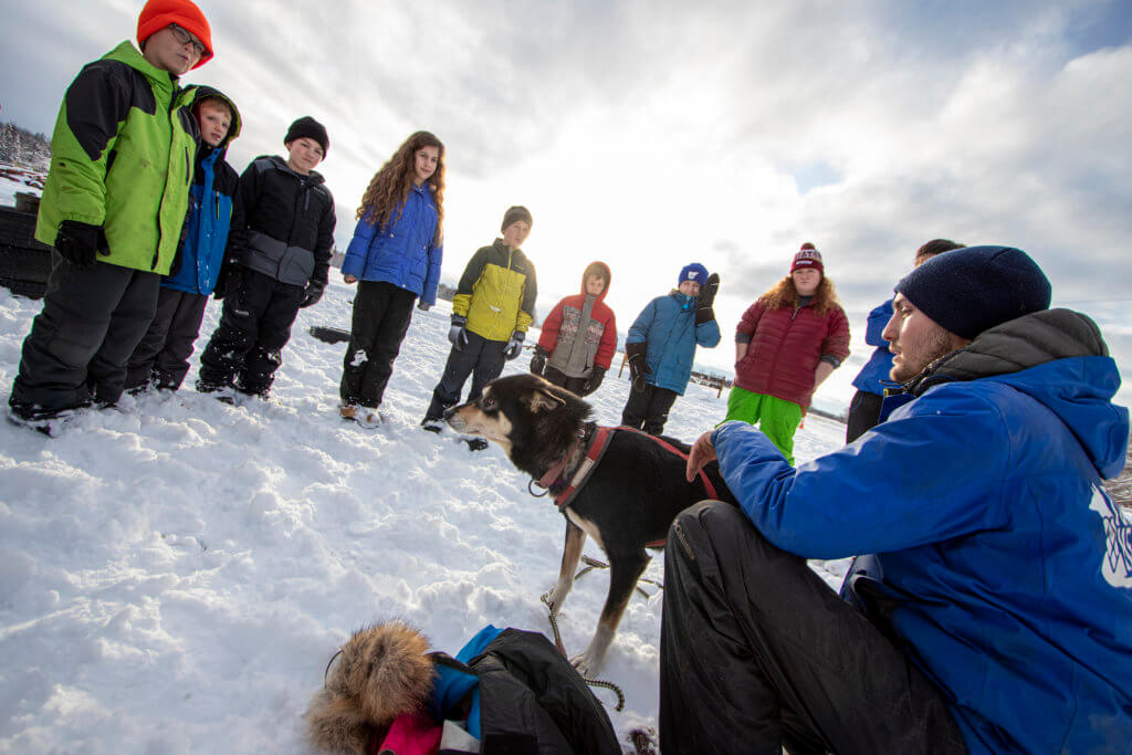  A sled dog handler shows Kellogg Field School students how to dress a sled dog for the trails.