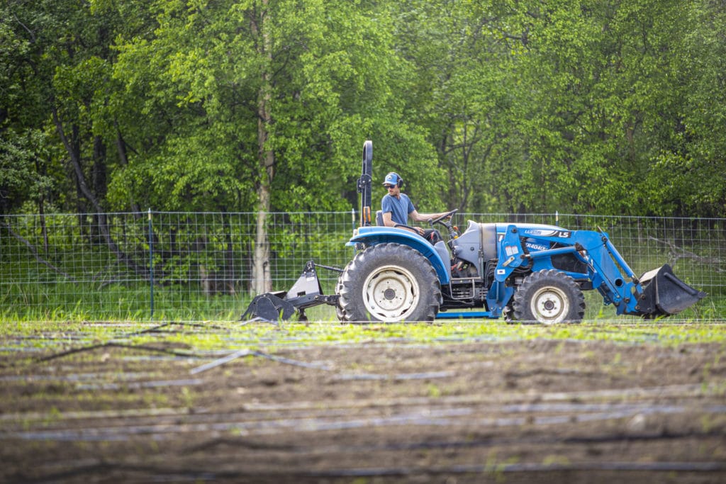 Student driving a tractor in a field