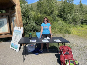 Lilly with the survey table at a trailhead in Anchorage
