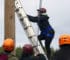 A student climbs a ropes course ladder
