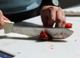 A close-up image of hands filleting salmon