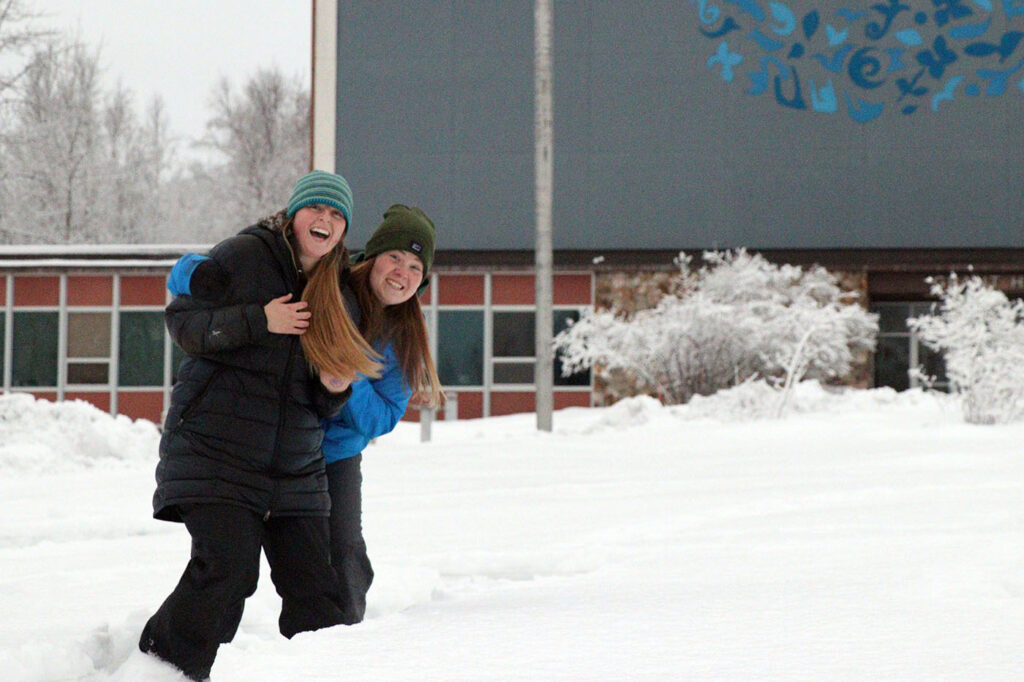 two female students walking outside of APU campus in the winter
