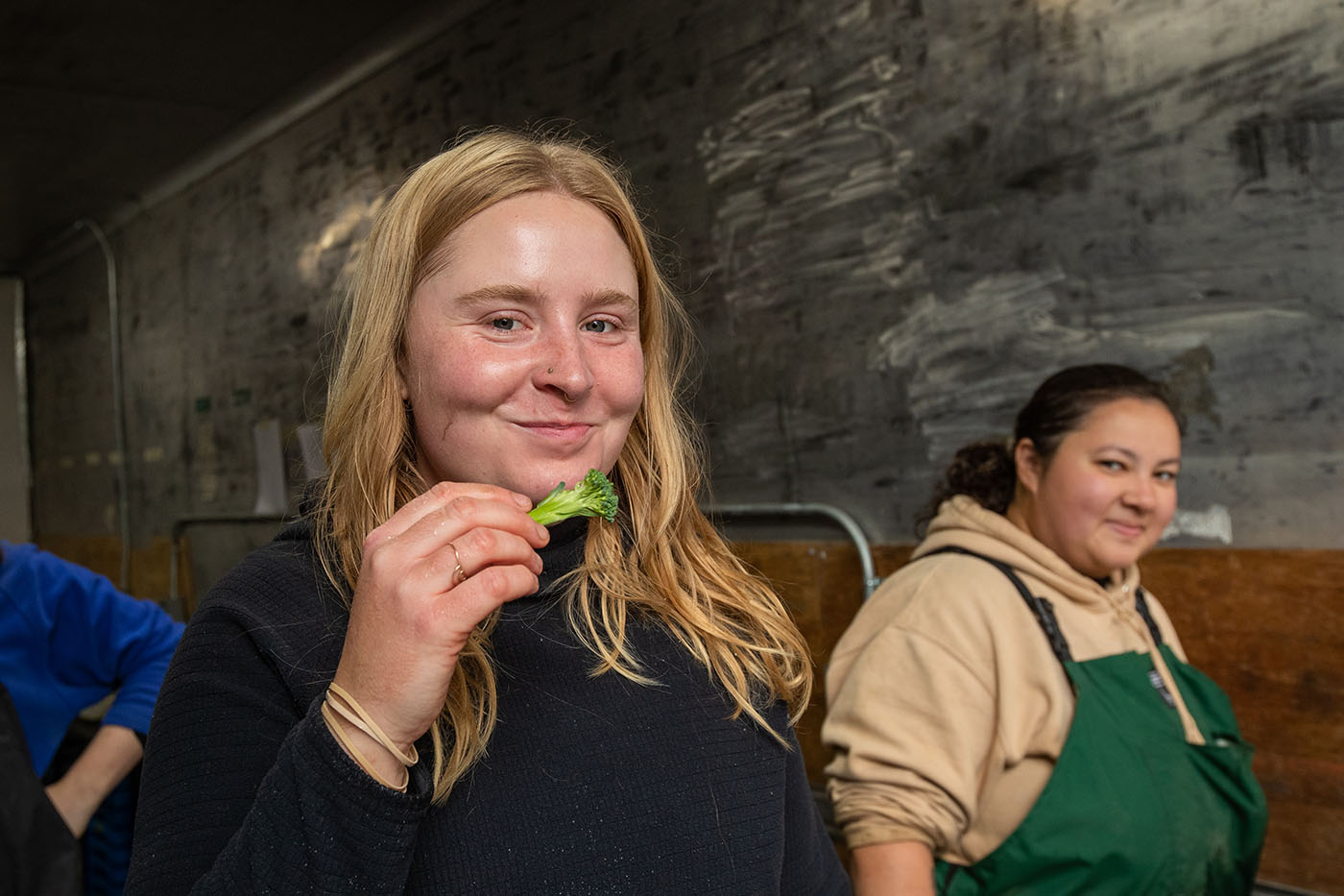 woman holding a piece of broccoli