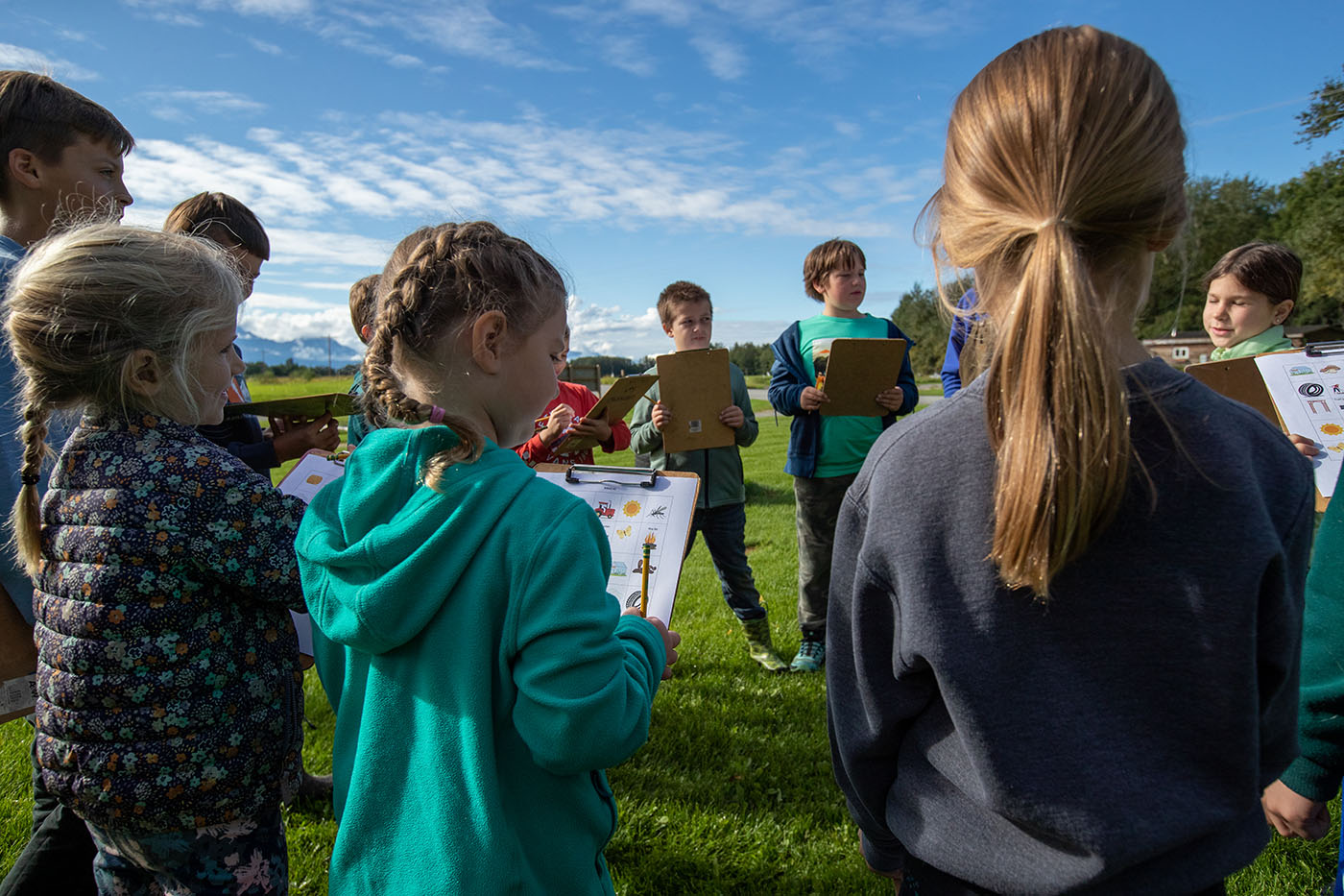 kids holding clipboards outside