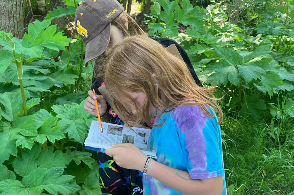 girl taking notes outdoors at Camp Kellogg
