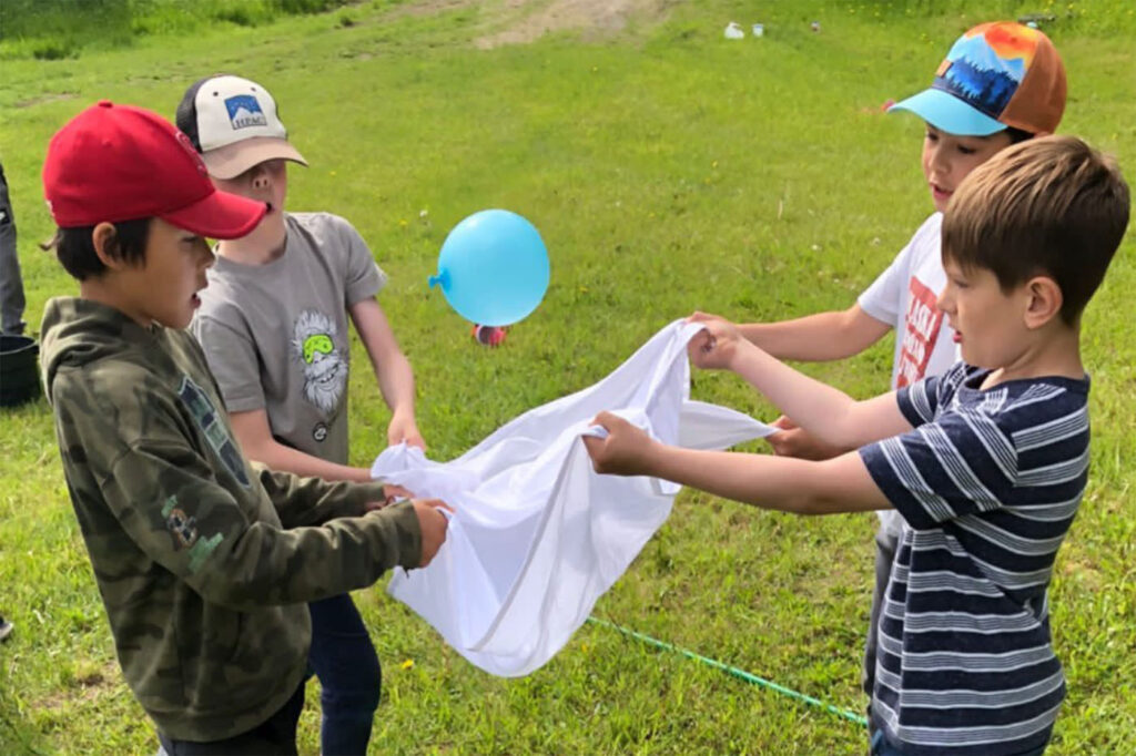 kids holding a white fabric